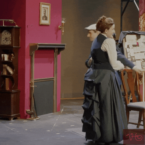 a man and woman are standing next to each other in a room with a sign that says ' ho ' on it