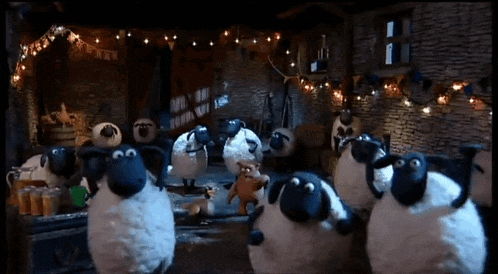 a bunch of sheep are standing in a room with a sign that says ' christmas ' on it