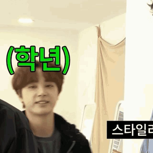 a man in a black jacket is smiling in front of a sign that says ' korean ' on it