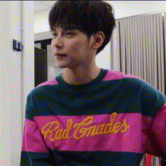 a young man wearing a pink and blue striped sweater with the word red grades on it .