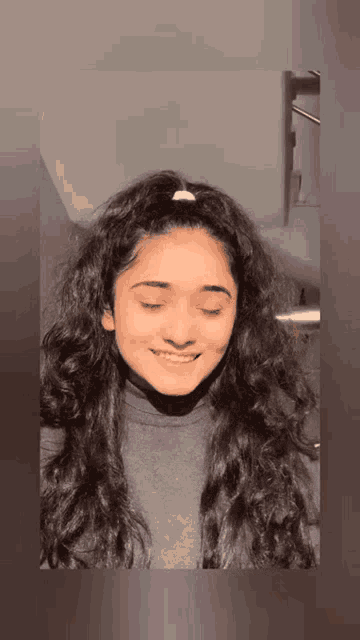 a young woman with her eyes closed and a ponytail on her head