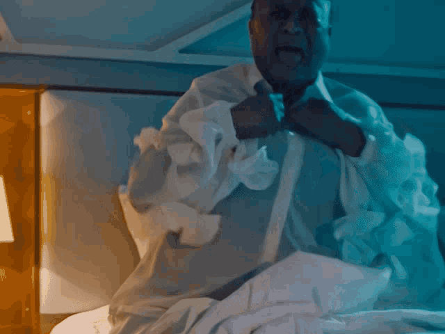 a man laying on a bed with white sheets