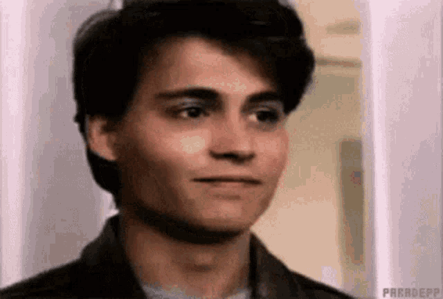 a close up of a young man 's face making a funny face .