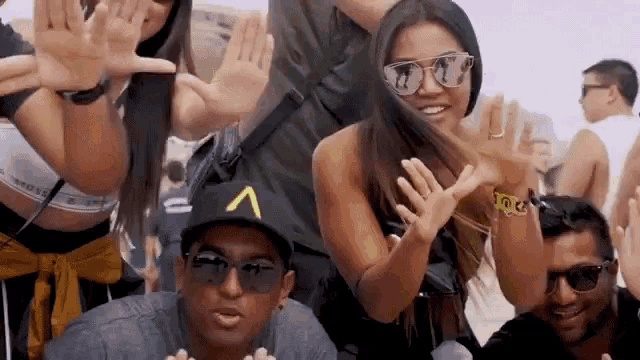 a group of people posing for a picture with one wearing a hat that says a on it