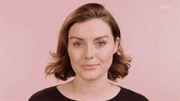 a close up of a woman 's face with her hands on her neck .