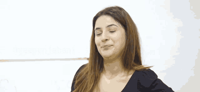 a woman in a black shirt is making a funny face .