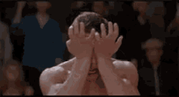 a shirtless man with blood on his nose is making a funny face .