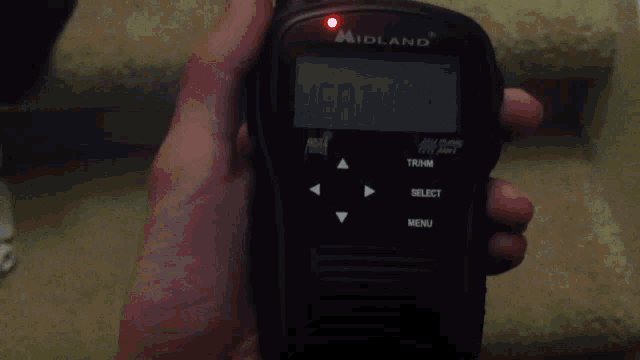 a hand holding a midland radio that says special