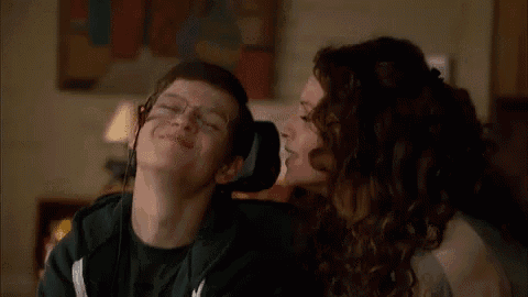 a woman is kissing a young boy on the cheek .