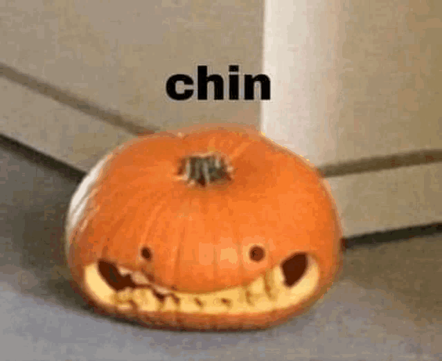 a pumpkin with a face carved into it is sitting on a floor .