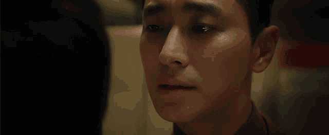 a close up of a man 's face with tears coming down his face .