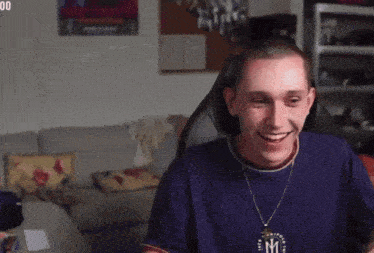 a man wearing a blue shirt with the letter m on it is making a funny face