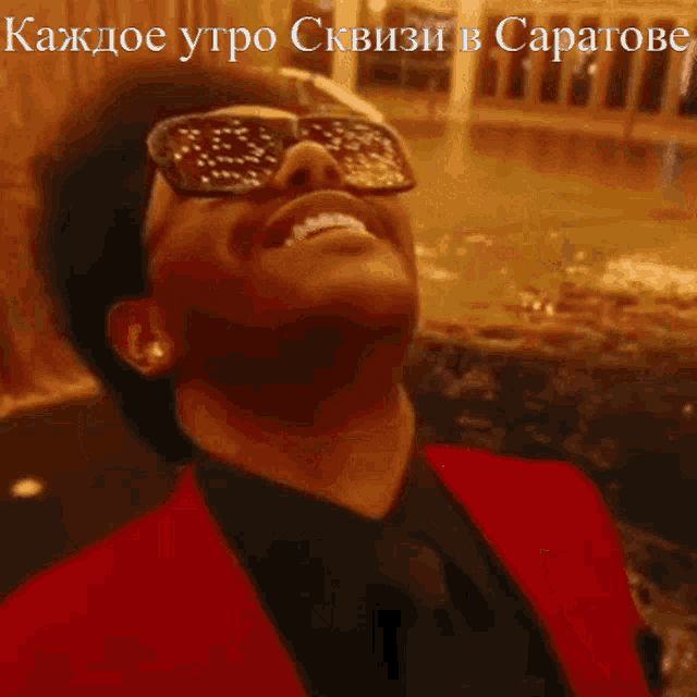 a man wearing sunglasses and a red jacket is laughing in a foreign language