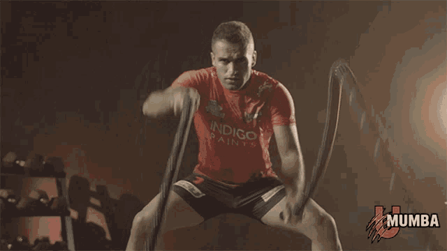 a man in a red shirt with the word mumba on the bottom right