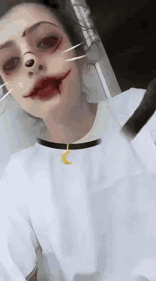 a woman wearing a white shirt with a crescent moon necklace