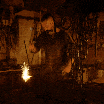 a man is working on a piece of metal and sparks are coming out of it