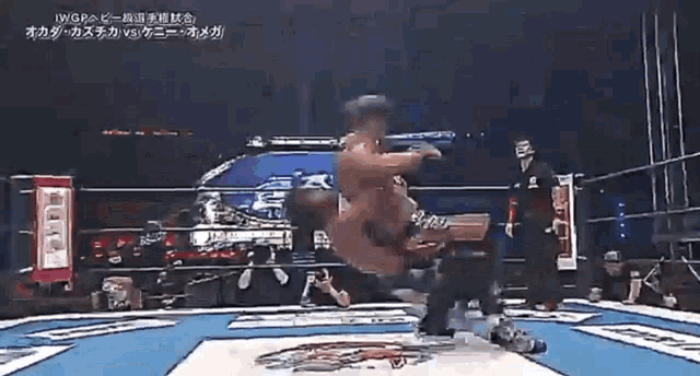 two men are fighting in a wrestling ring with a referee watching .