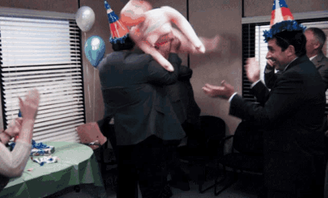 a group of people wearing party hats and balloons are dancing