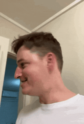 a close up of a man 's face with a white shirt