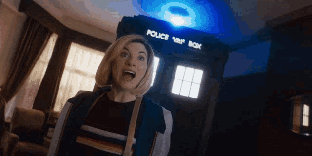 a woman standing in front of a police box with her mouth open