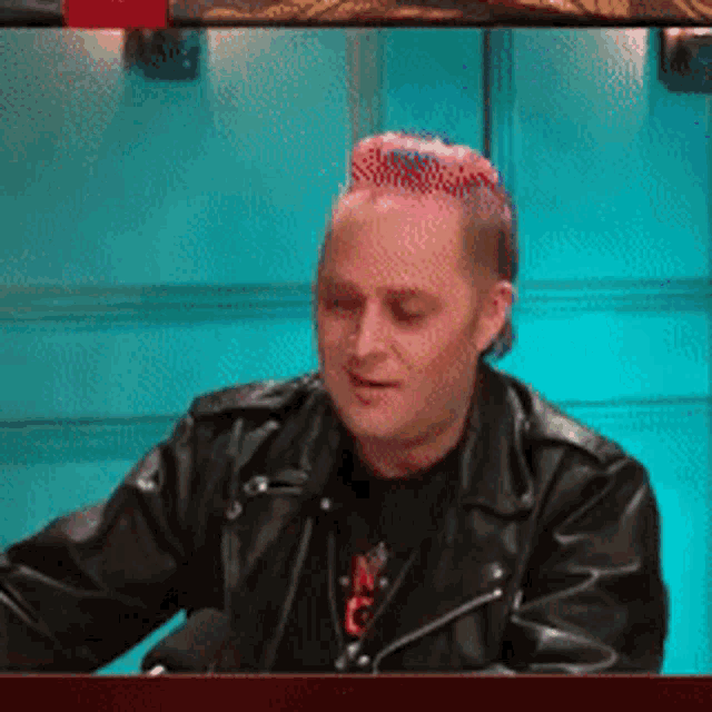 a man in a black leather jacket with a red and blue mohawk