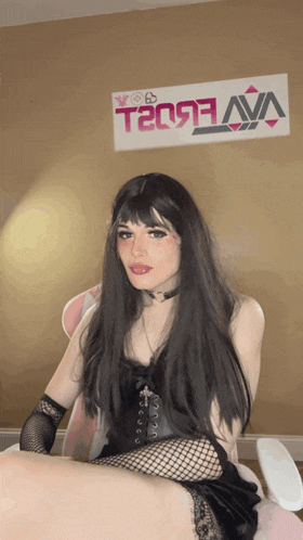 a woman sitting in front of a wall with a sign that says teo93 ava