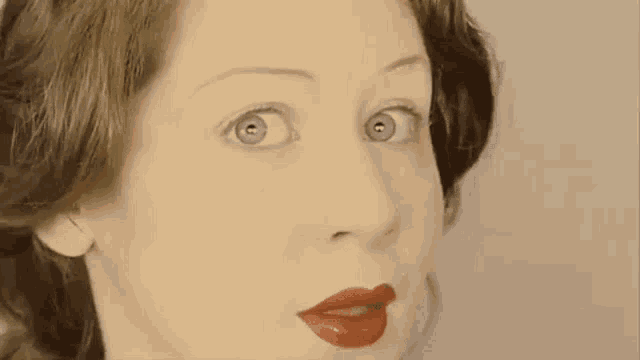 a close up of a woman 's face with red lipstick on .