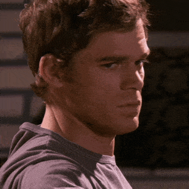 a close up of a man 's face with a gray shirt on