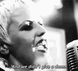 a woman is singing into a microphone with the words `` and we didn t give a damn '' .