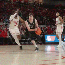 a basketball player with the number 13 on his jersey is dribbling the ball