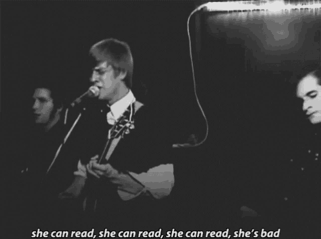 a man singing into a microphone with the words she can read