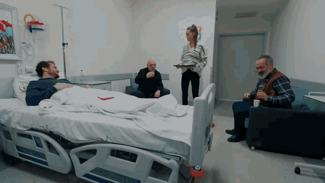 a man is laying in a hospital bed with a woman standing behind him