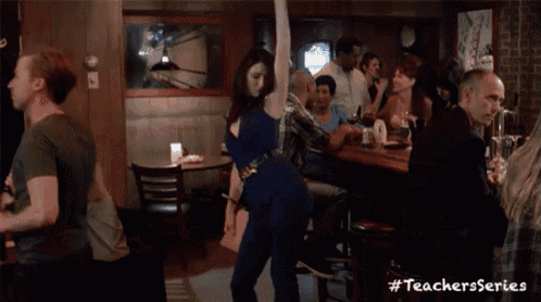 a woman in a blue dress is dancing in a bar with the hashtag #teachersseries on the bottom