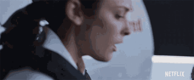 a close up of a woman 's face with a netflix logo behind her