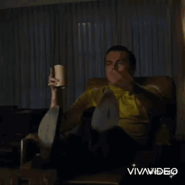 a man is sitting in a chair and pointing at something with the words " it 's myles " behind him