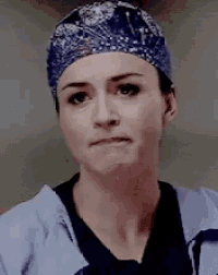a woman wearing scrubs and a surgical cap