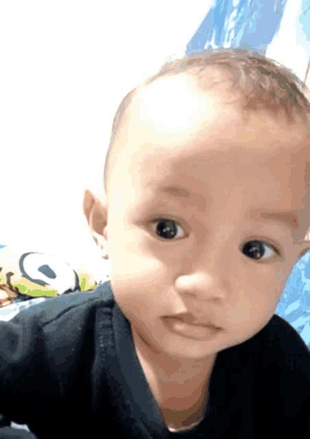 a close up of a baby 's face with a blue background