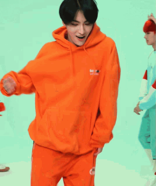 a man wearing an orange hoodie that says safety first on it