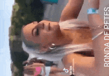 a woman with a shaved head is wearing hoop earrings and a wristband .