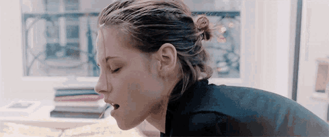 a close up of a woman 's face with her eyes closed and a cigarette in her mouth