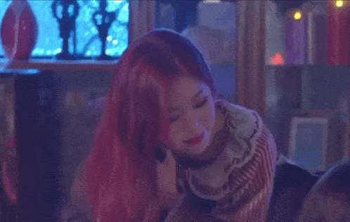 a woman with red hair wearing a striped shirt is smiling