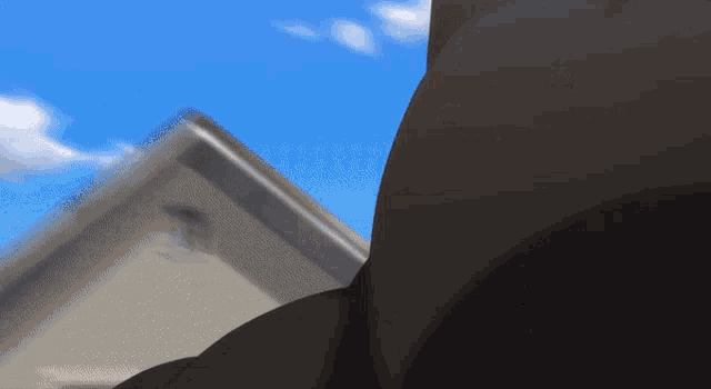 a close up of a person 's butt in front of a blue sky with clouds