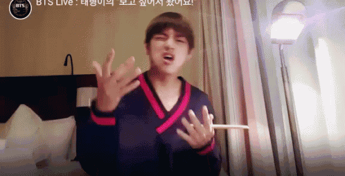a man in a black and red sweater is making a funny face in front of a window