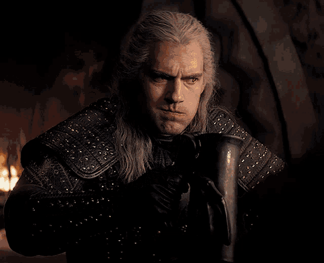 a man with gray hair is wearing a black leather outfit