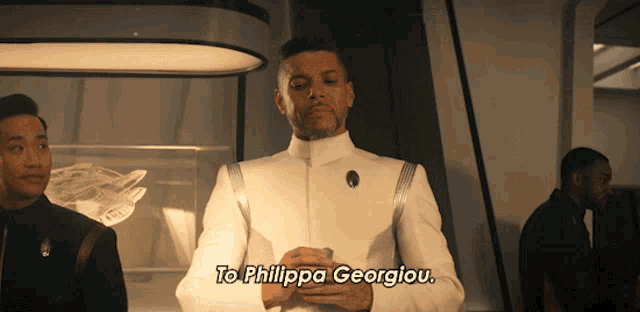 a man in a white uniform says to philippa georgiau