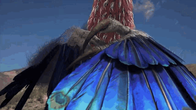 a close up of a bird 's feathers against a blue sky with mountains in the background