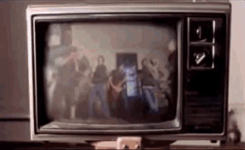 a television shows a group of people playing guitars on the screen