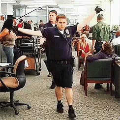 a man in a police uniform is standing in a room with his arms outstretched