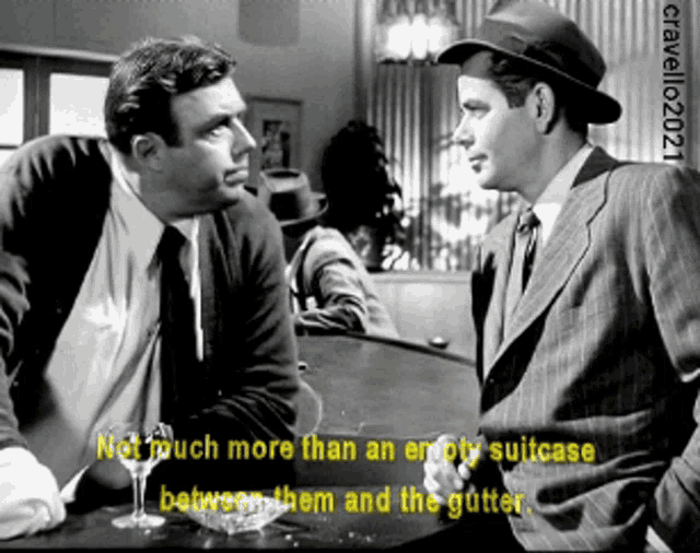 a black and white photo of two men talking with a caption that says not much more than an empty suitcase between them and the gutter