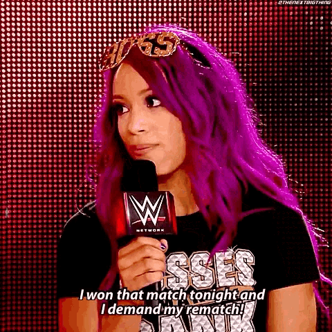 a woman with purple hair is standing in front of a microphone .
